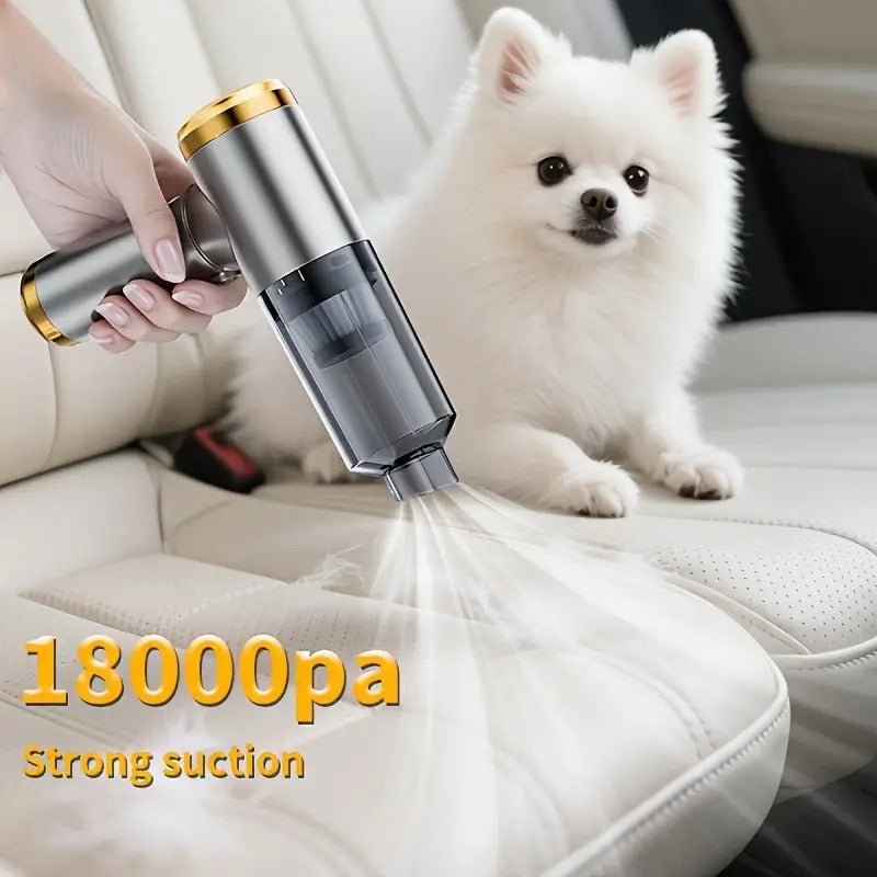 Hand holding a handheld vacuum cleaner with a white dog sitting on a car seat, emphasizing strong suction power.